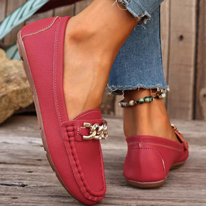 Red round-toe loafers with gold chain detail and stitched accents.
