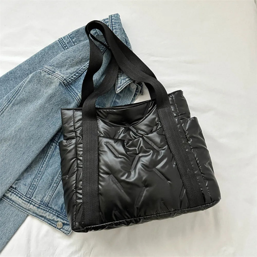 Black padded nylon tote bag with exterior pockets and quilted stitching detail.