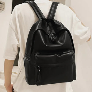 Black leather backpack with front pocket and tassel zipper detail