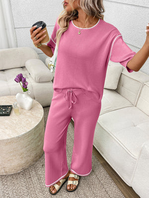 Fuchsia pink loungewear set with crew neck top and drawstring pants, white piping detail
