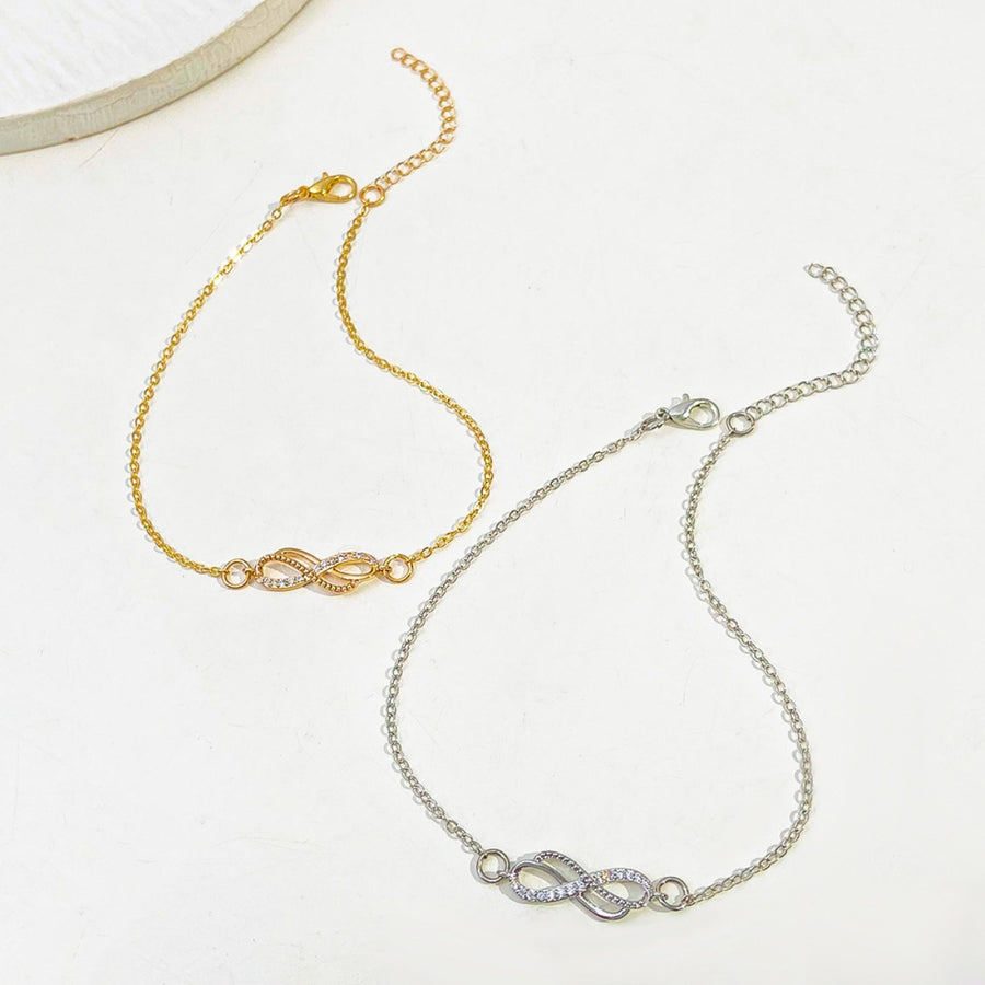 Gold and silver infinity knot charm bracelets with adjustable chains and crystal accents.
