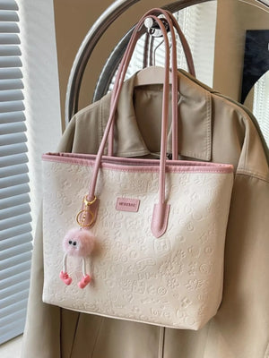 Embossed PU leather tote bag in white with pink trim and a fuzzy charm.