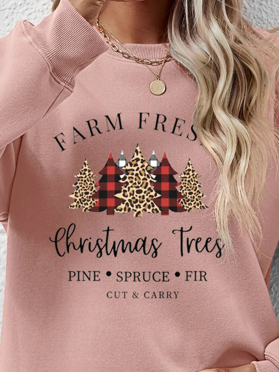 Blush pink crewneck sweatshirt with Christmas trees graphic and text.
