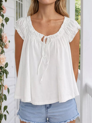 White tie-front gathered blouse with short sleeves and a scoop neckline.