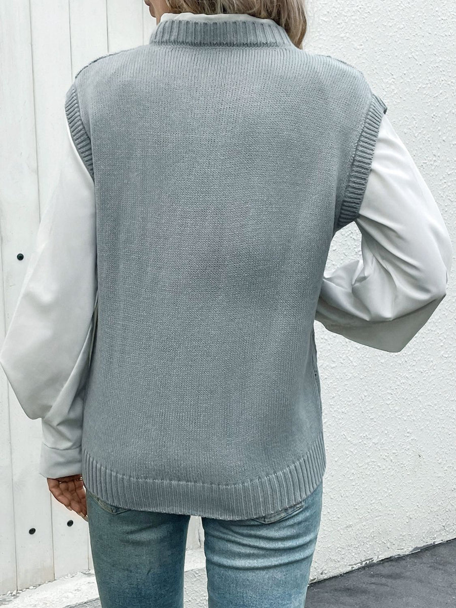 Gray acrylic diamond knit V-neck vest with ribbed trim, layered over a white shirt.