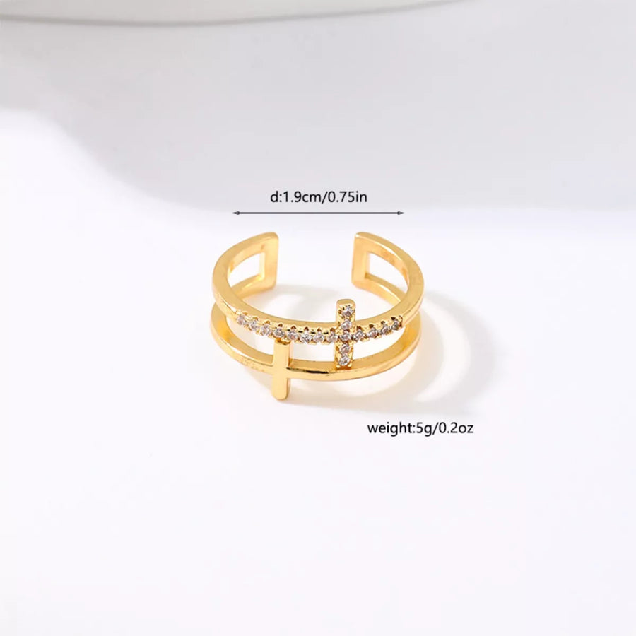 Golden open ring with rhinestone cross detail and double band design.
