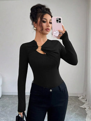 Black long-sleeve tee with asymmetrical cutout and gold ring detail.