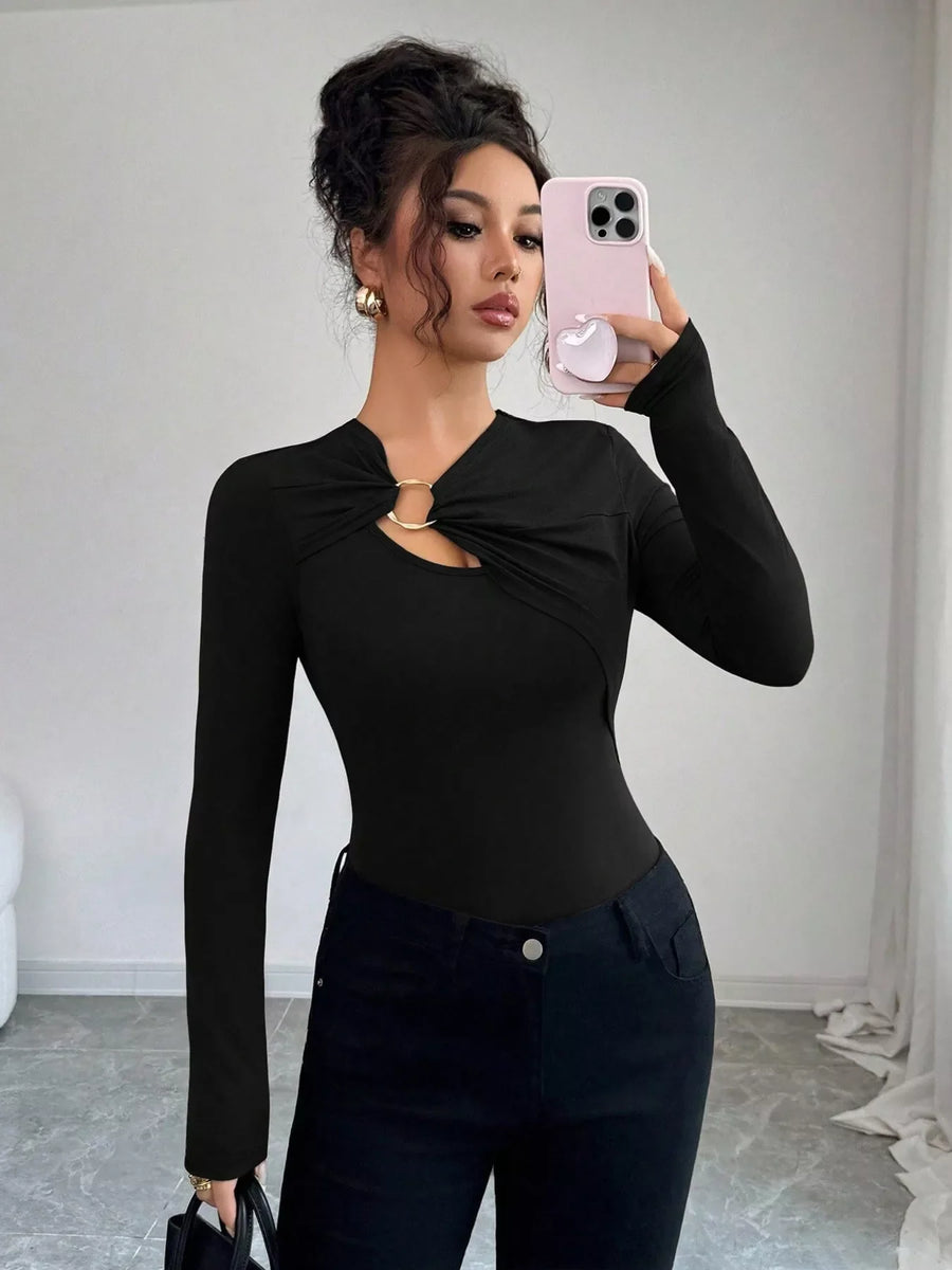 Black long-sleeve tee with asymmetrical cutout and gold ring detail.