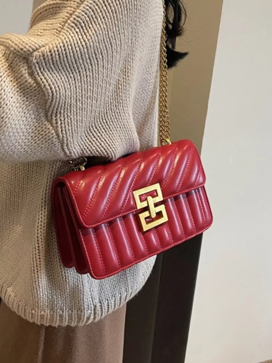Chic quilted crossbody bag in wine red with gold chain and clasp.