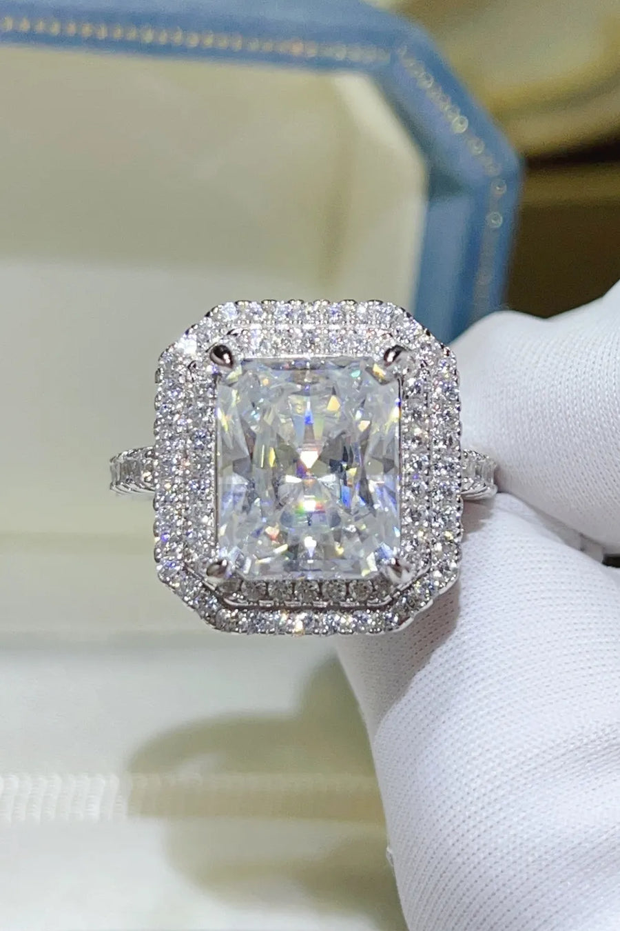 Radiant cut moissanite halo ring in silver with pave band.