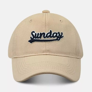 Baseball cap in tan cotton with embroidered navy Sunday text and underline detail.