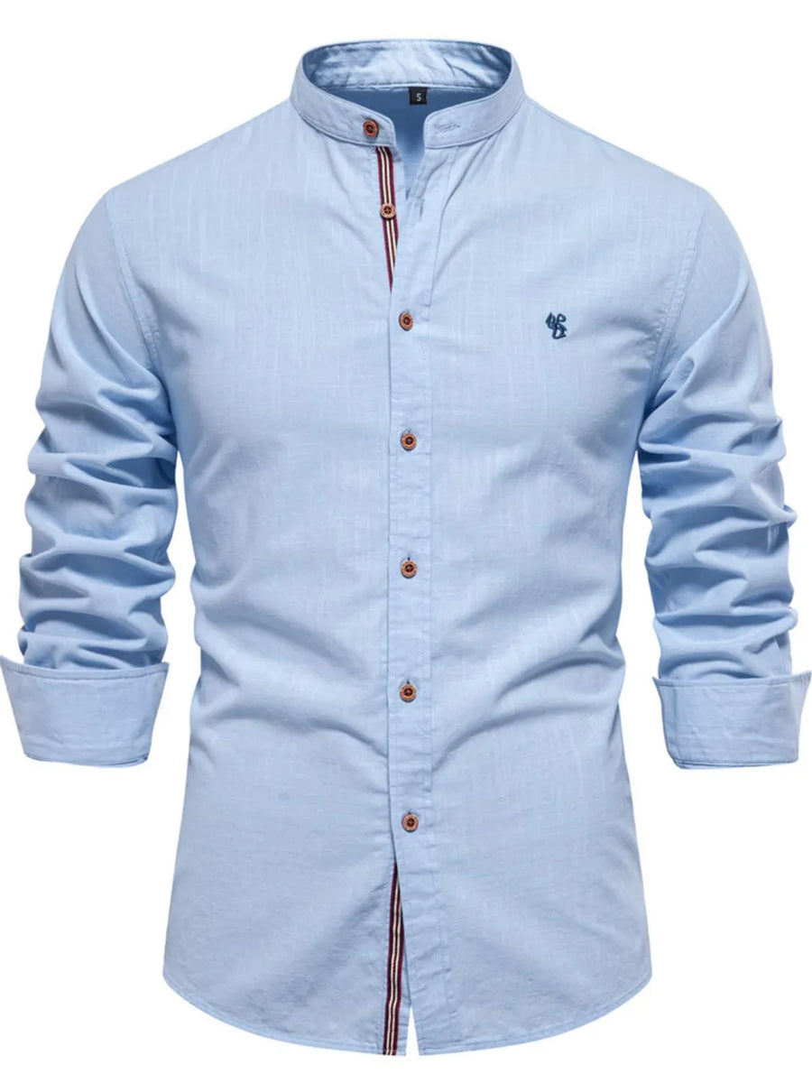 Light blue linen shirt with mandarin collar, button front, and embroidered detail.