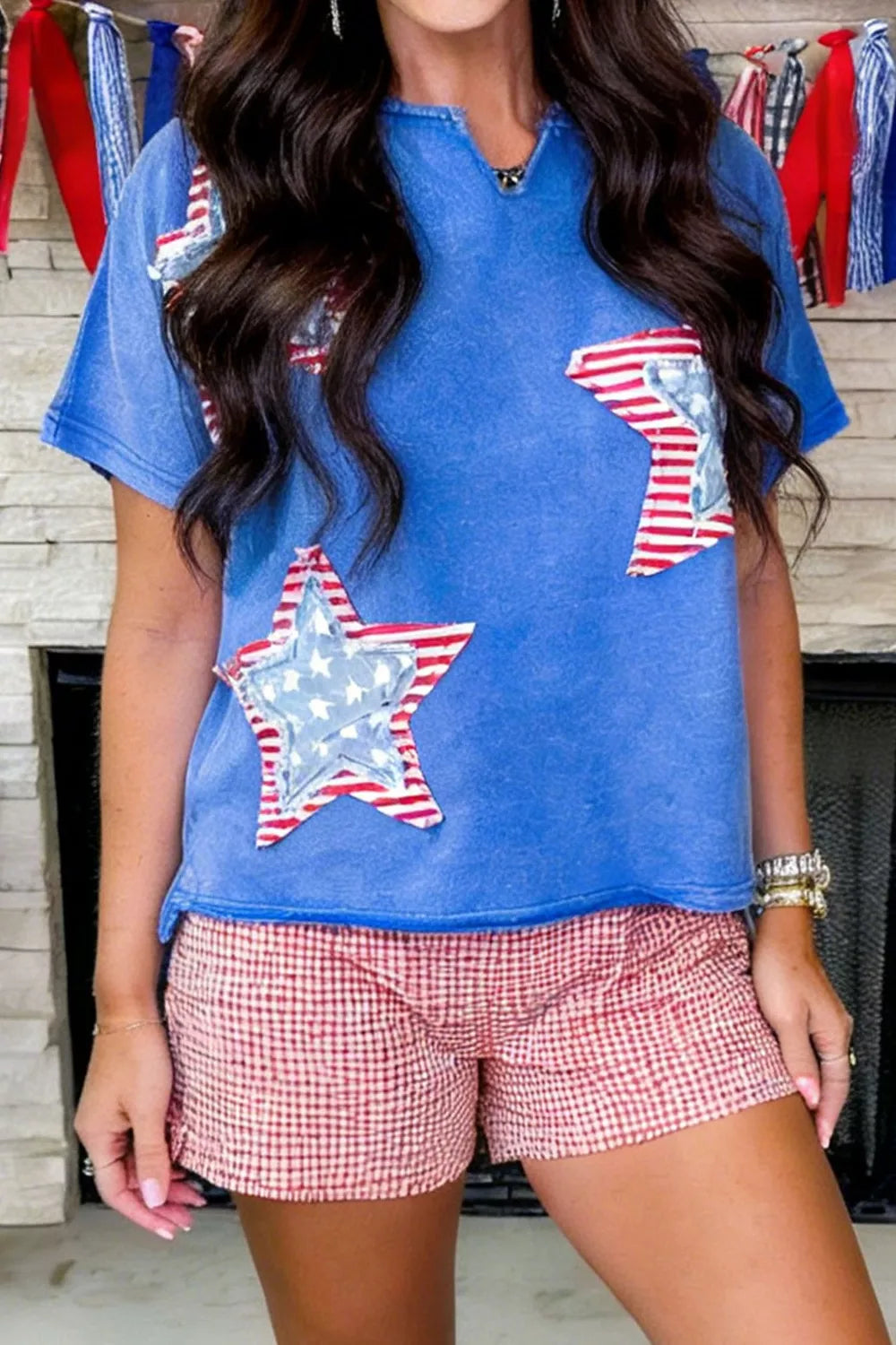 Blue cotton t-shirt with notched neck and patriotic star appliqué details.