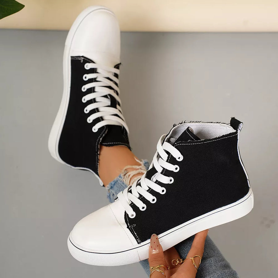 Black and white canvas lace-up high-top sneakers with white soles.