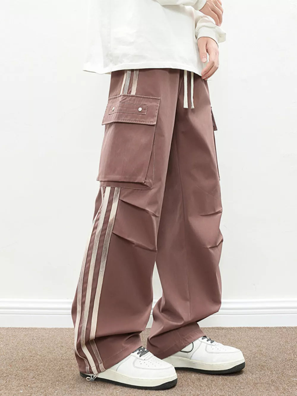 Oversized cargo pants in dusty pink with flap pockets and side stripe detail.