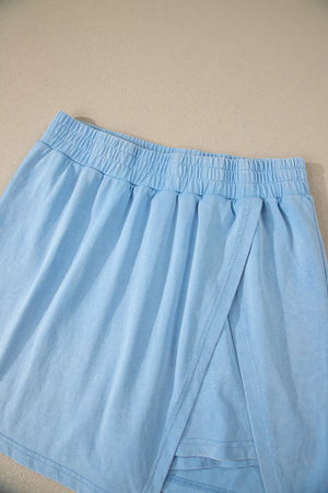 Light blue cotton skort with elastic waistband and wrap detail