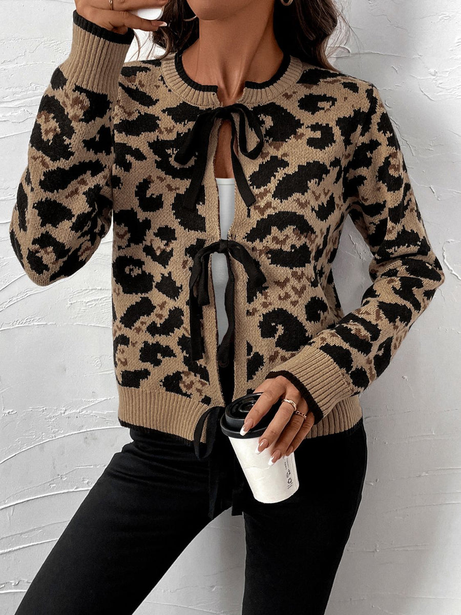 Tan leopard print acrylic knit cardigan with black tie details at the neckline and hem.