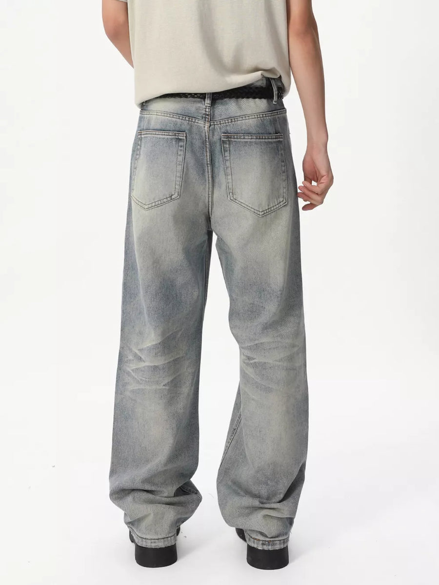 Men's light blue vintage wash wide leg jeans with a relaxed fit.