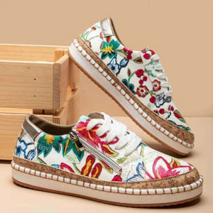 Floral zip-up sneakers with cork sole and white laces.