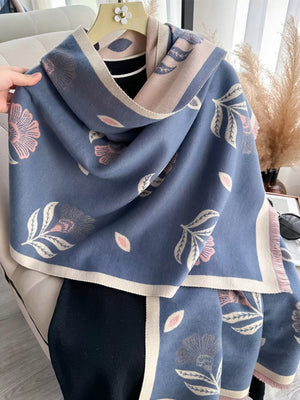 Blue floral print fringed shawl with cream and pink trim, styled casually.