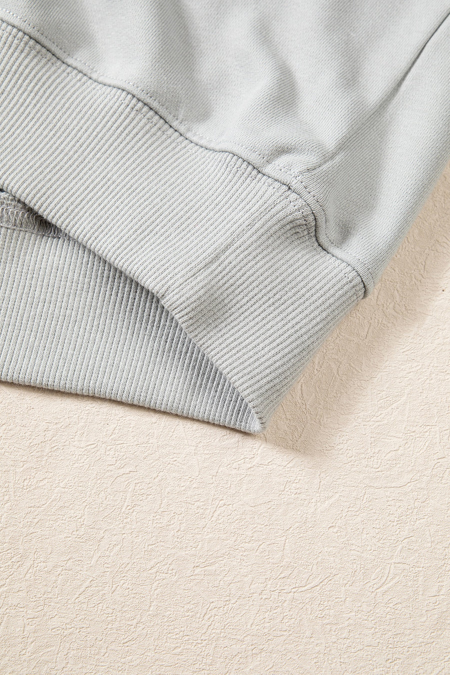 pullover sweater in light pink with chenille patch and hip-length