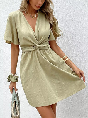 Twist waist mini dress in light green with flutter sleeves and a V-neck.