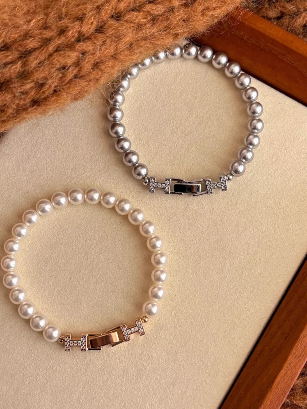 Pearl bracelets in silver and gold with zircon-accented buckles