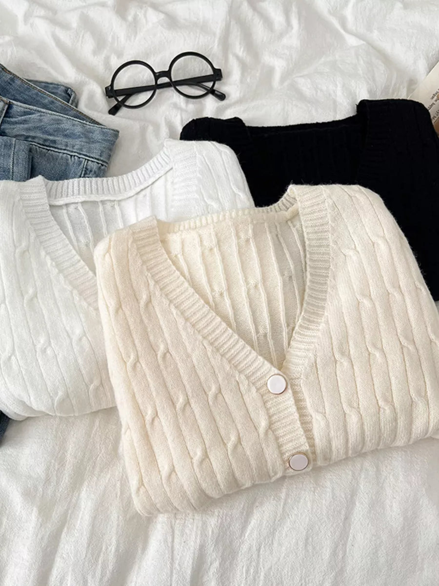 Apricot cable-knit cropped cardigan with buttons, white and black cardigans also shown.