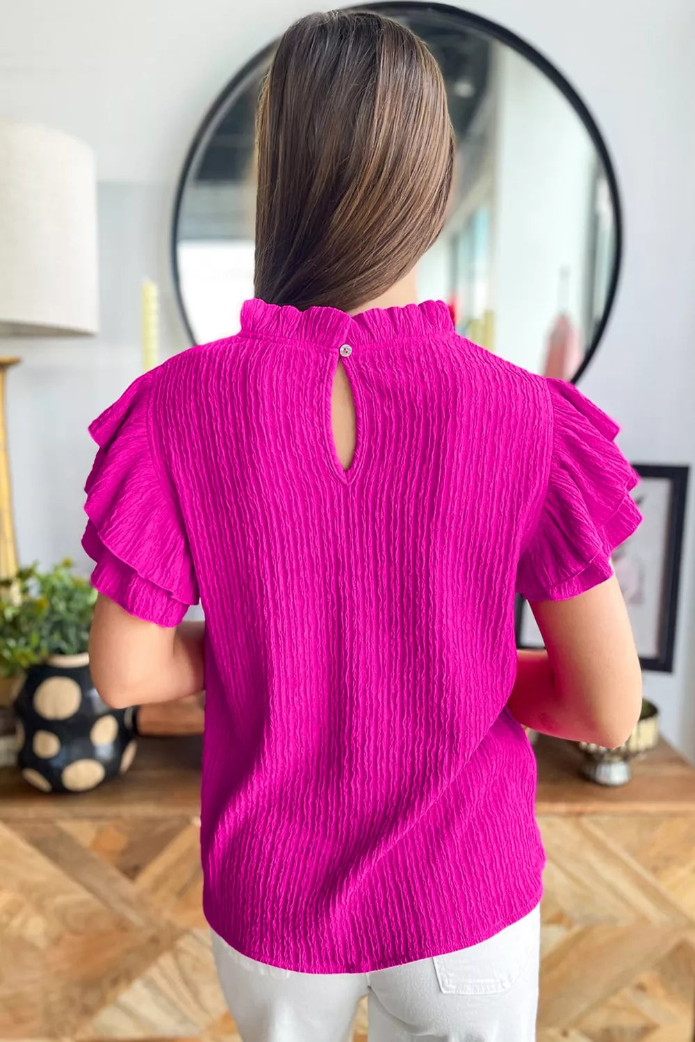 Textured ruffle trim blouse with mock neck and keyhole back.