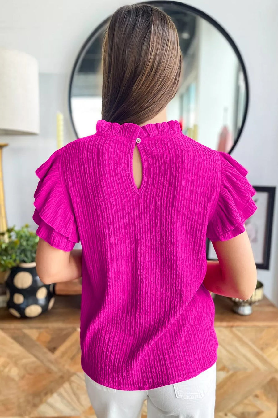 Textured ruffle trim blouse with mock neck and keyhole back.