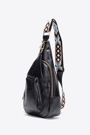 Black textured sling bag with woven strap detail and adjustable strap.