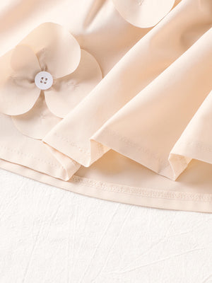 Off-white cotton baby dress with flower appliqués and ruffle sleeves.