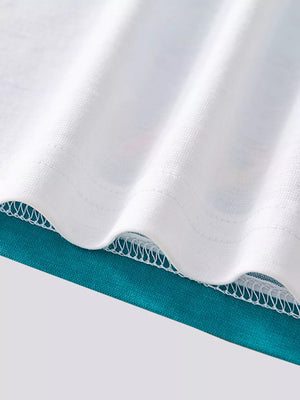 White t-shirt hem detail with teal fabric underneath and zigzag stitching.