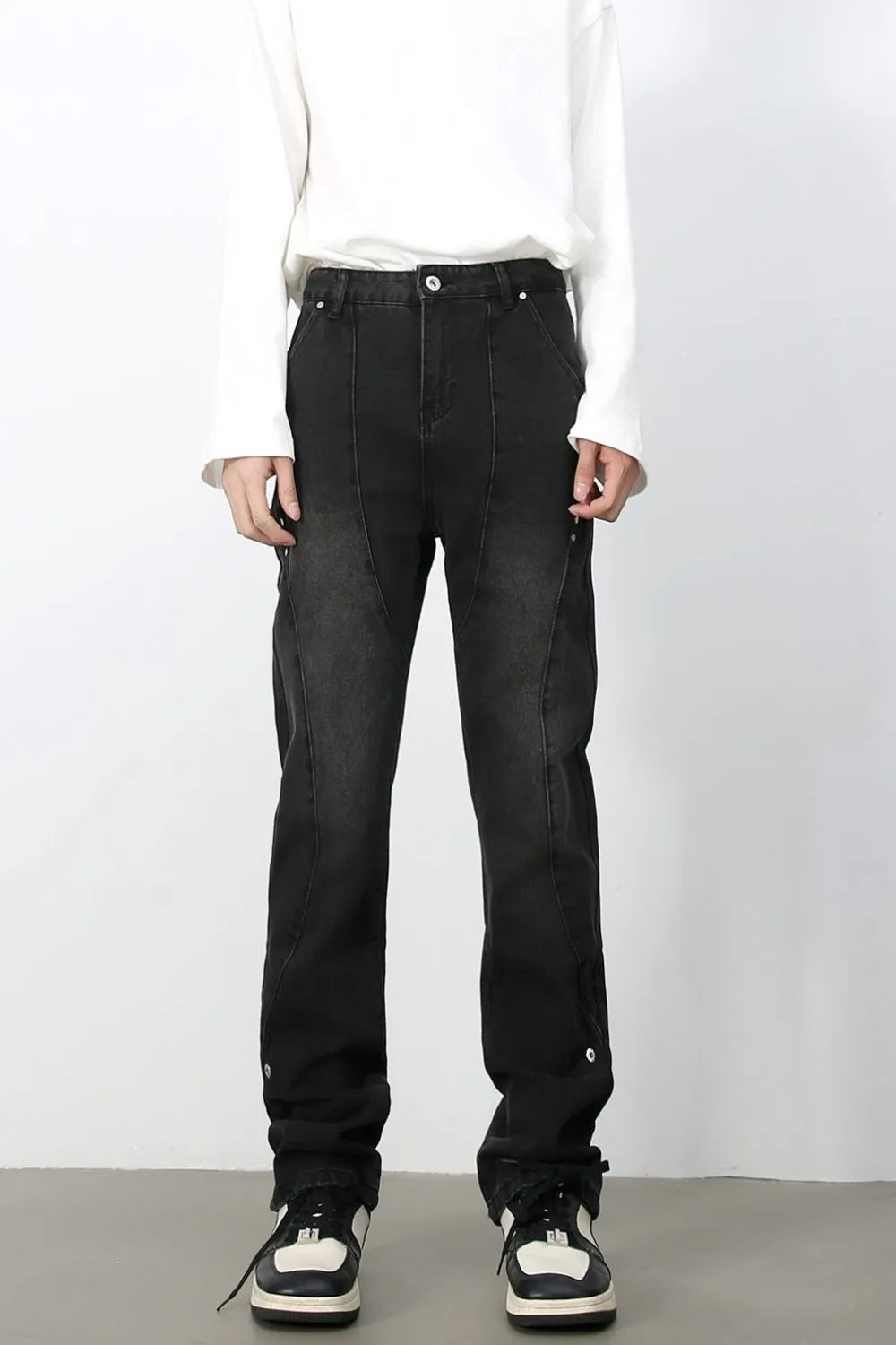Dark wash denim trousers with asymmetric seams and button details
