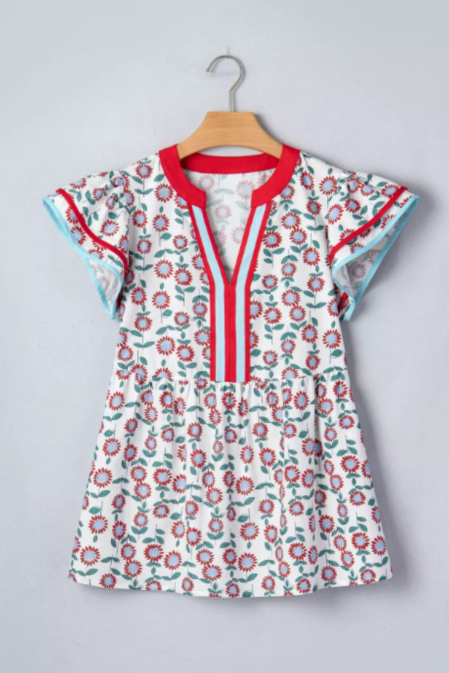 Vibrant floral cotton blouse with ruffle sleeves and contrast trim neckline.