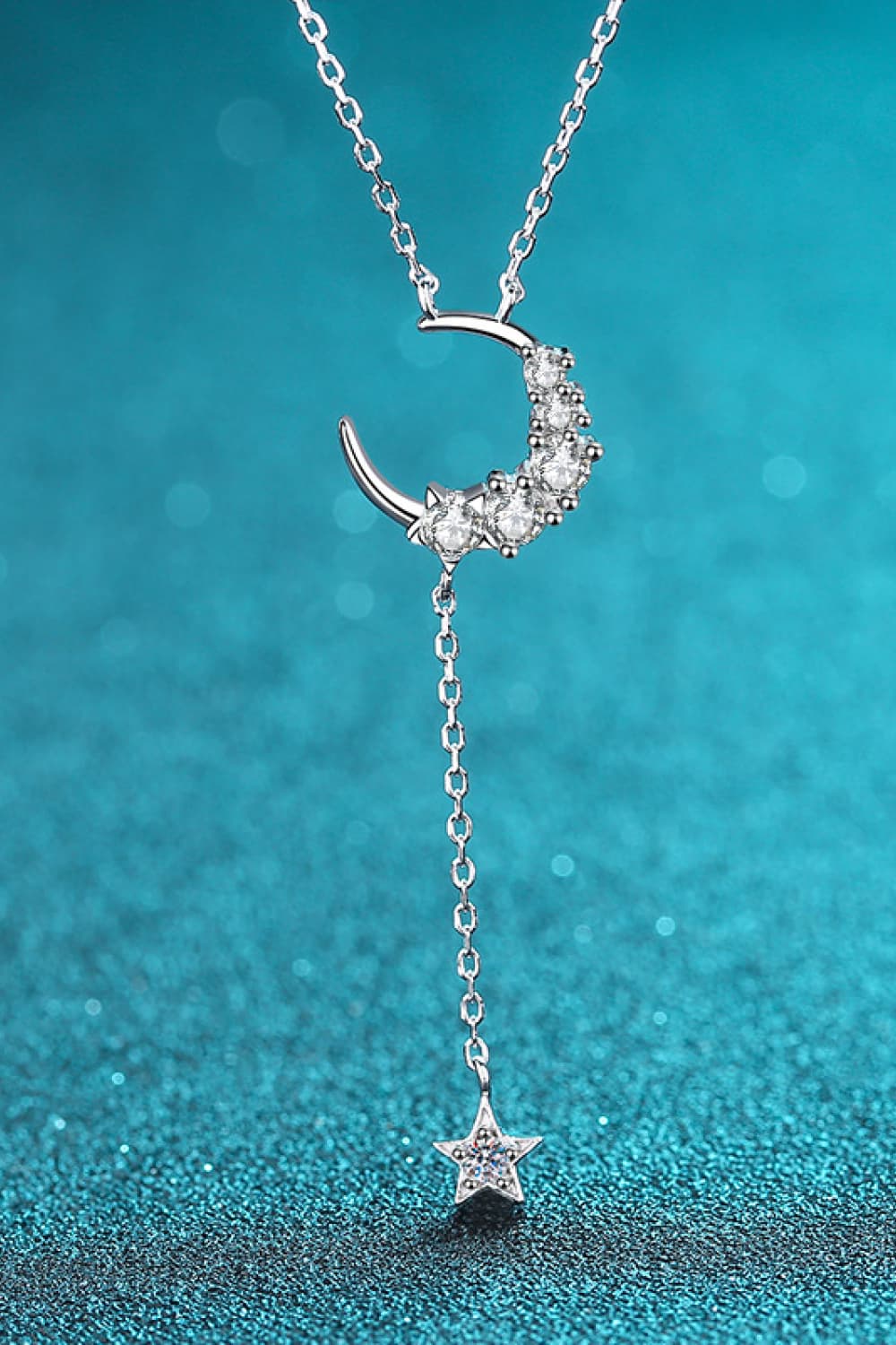 Silver celestial pendant necklace with crescent moon and star charms.