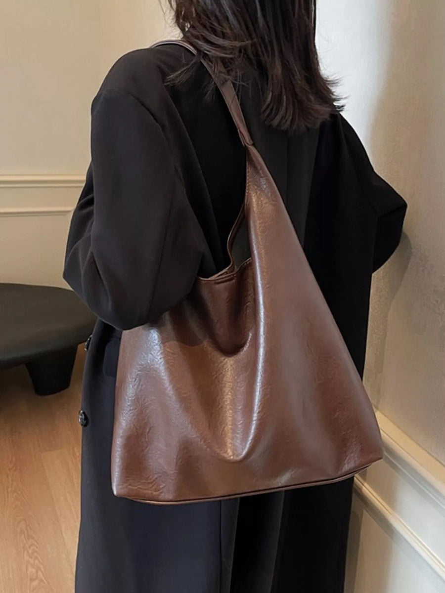 Sculptural PU leather tote bag in brown with a slouchy silhouette and single strap.