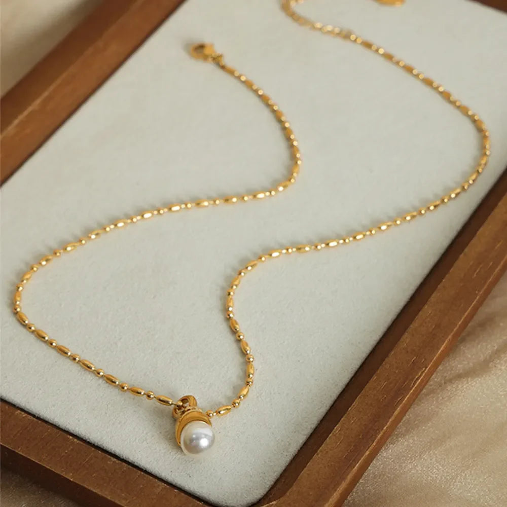 Gold pearl drop necklace with a delicate beaded chain.