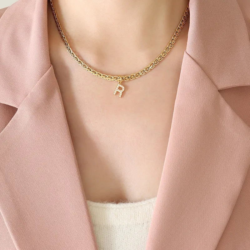 Gold textured chain necklace with a sparkling initial R charm