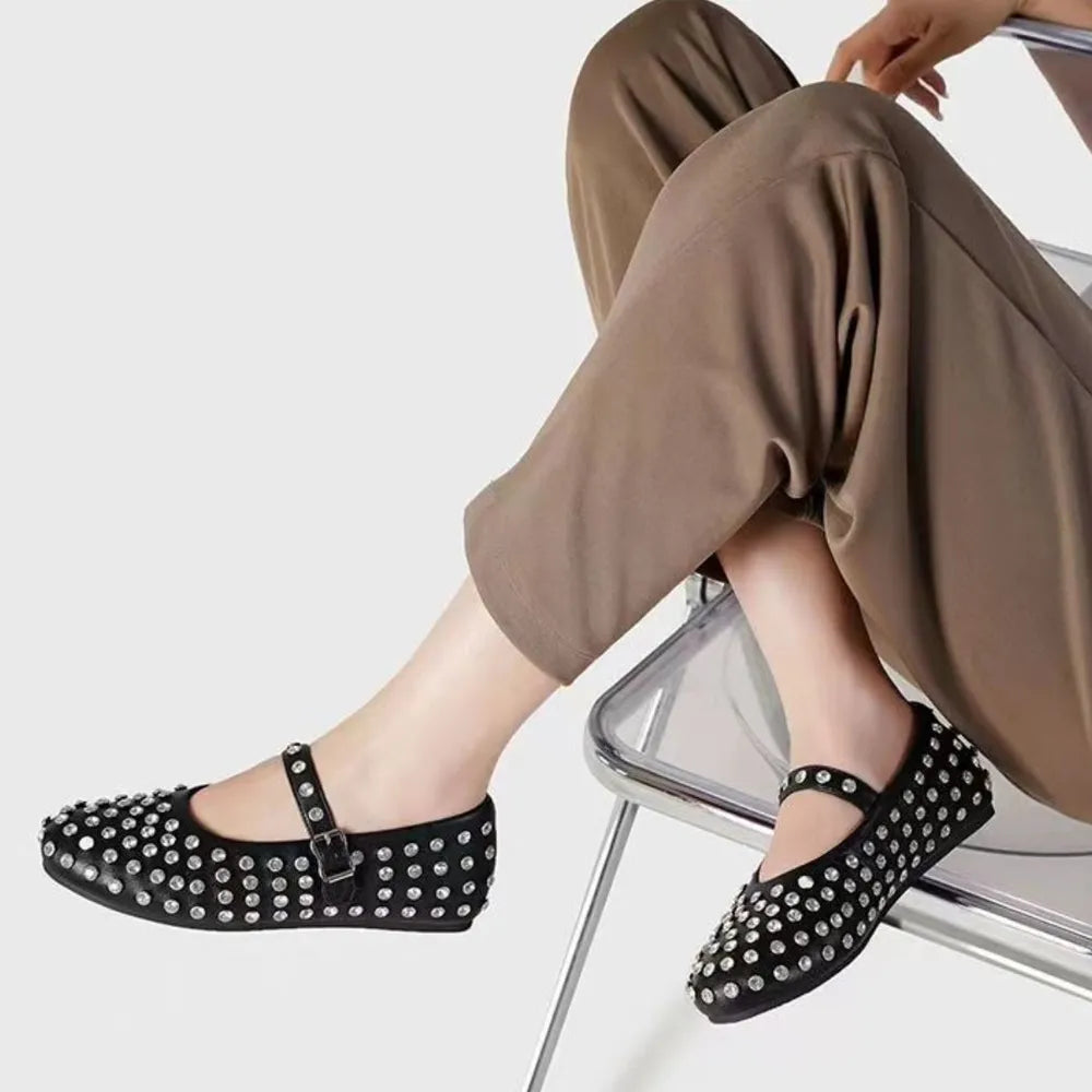 Black studded Mary Jane flats with ankle strap and buckle detail.