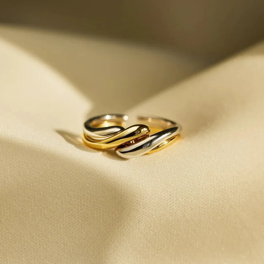 Two-tone gold intertwined open ring with a smooth, fluid design.