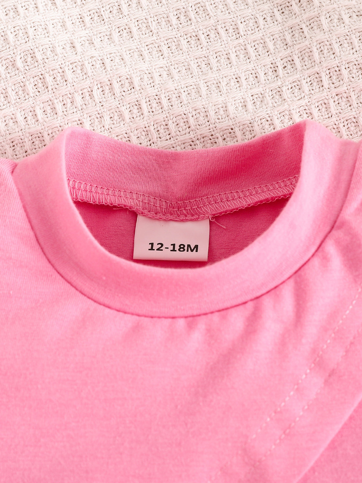 Pink toddler crop top with crew neck and size tag