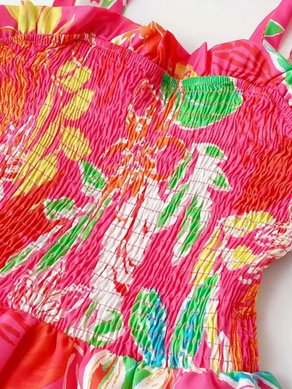 Tropical tie-strap smocked midi dress in strawberry pink with a floral print and ruffled neckline.