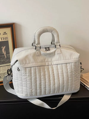Chic quilted nylon travel bag in cream white with adjustable strap and padded handles.