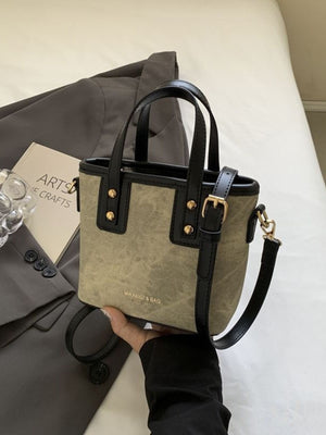 Mini chest bag in brown canvas with black leather trim and gold hardware.