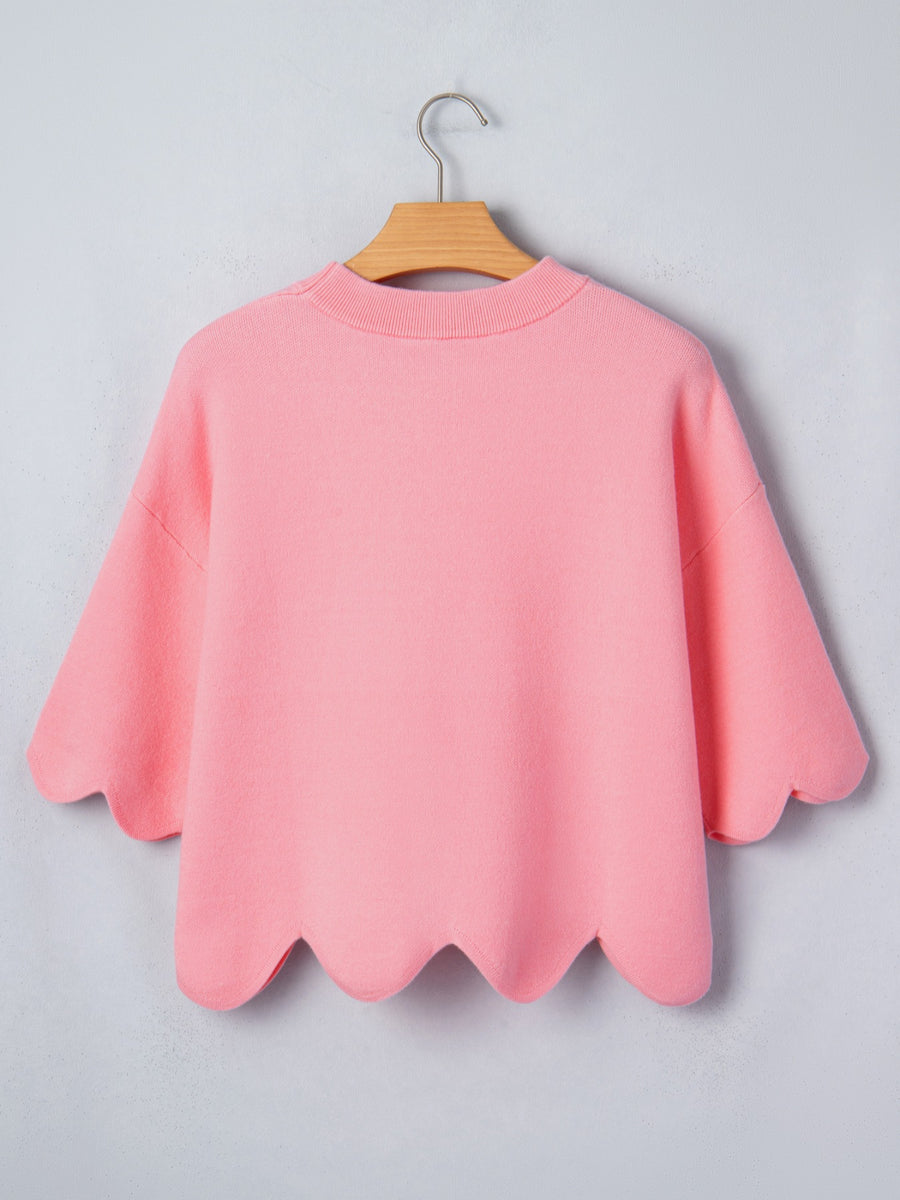 Pink knit sweater with scalloped hem and sleeves