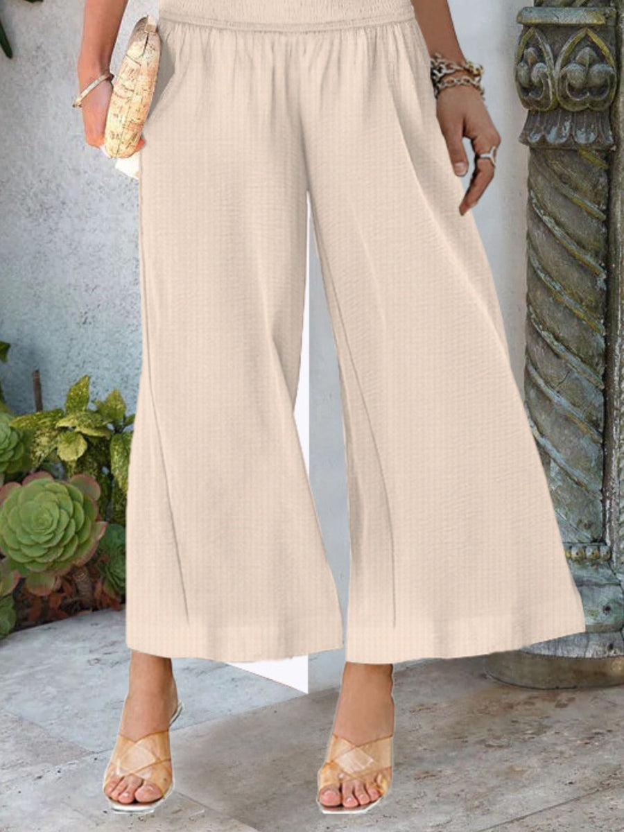 Smocked waist wide-leg pants in light brown with pockets, ankle-length, casual, comfortable.