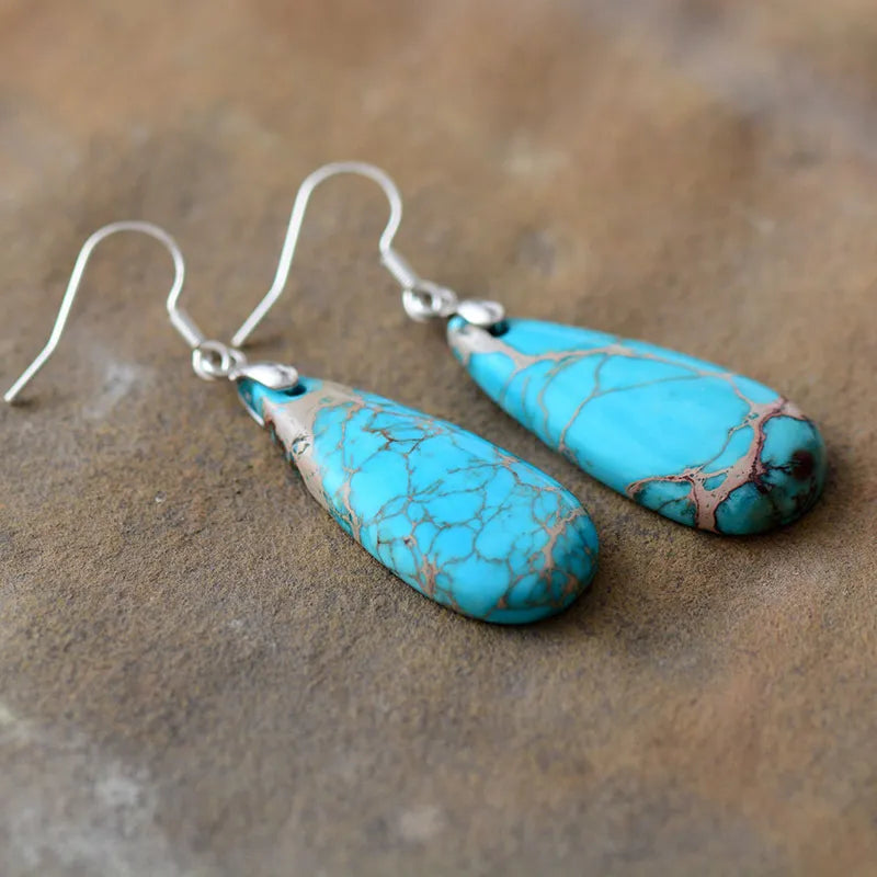 Turquoise vein teardrop dangle earrings with silver hooks.