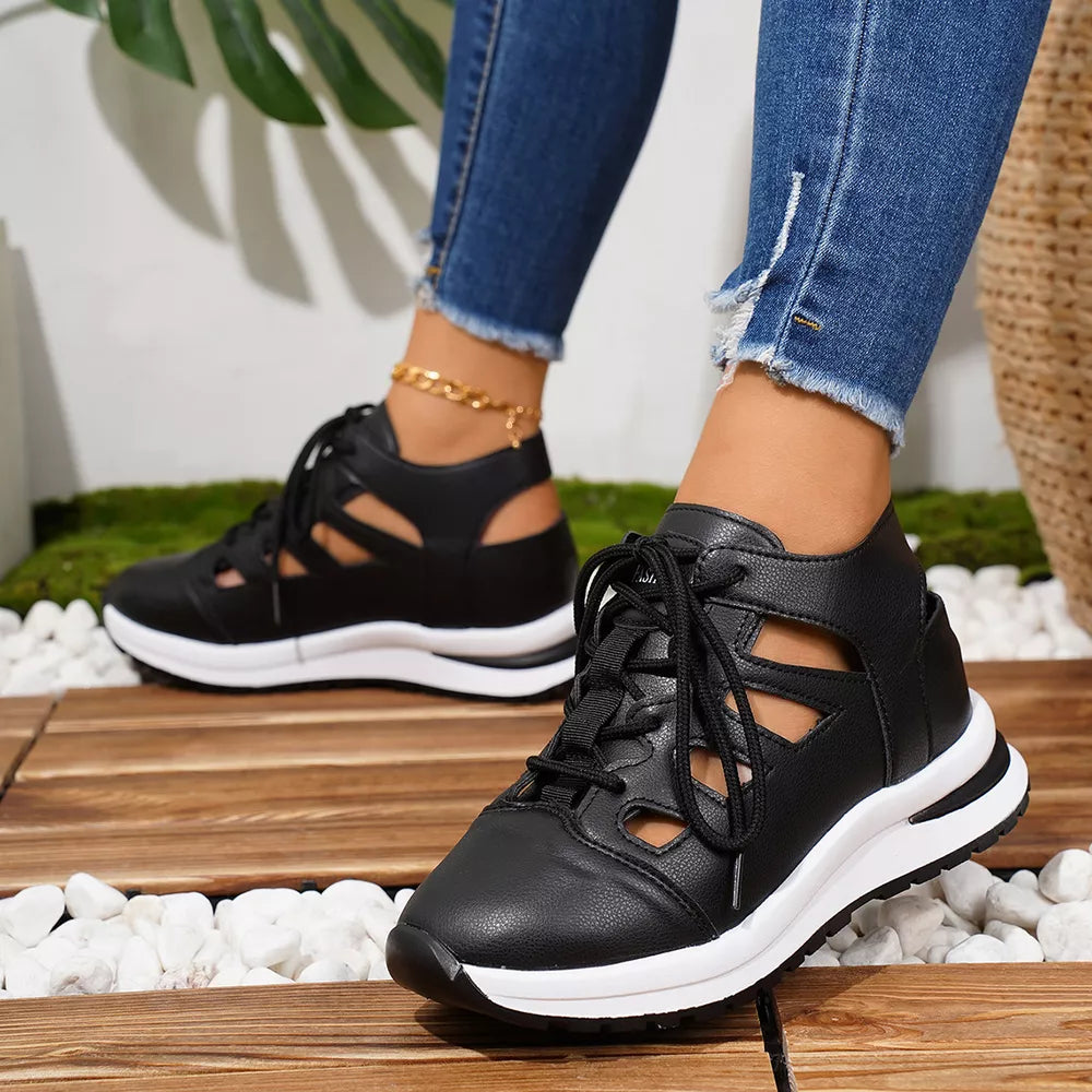 Chic black round toe lace-up sneakers with cut-out details and white soles.