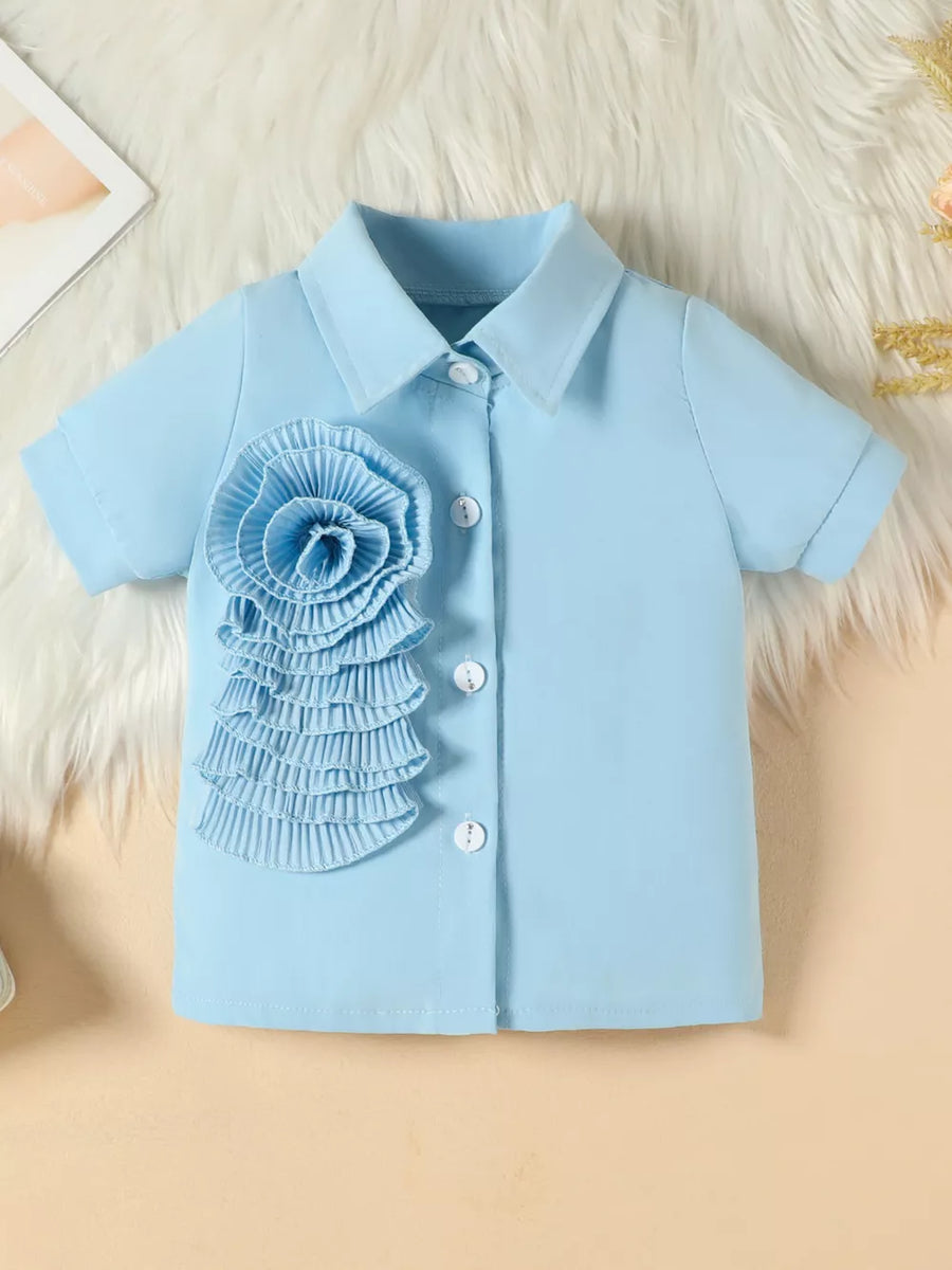 Blue toddler shirt with floral appliqué and decorative buttons